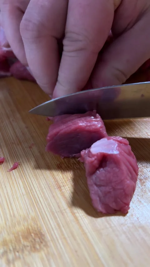 Man cutting piece of fresh raw juicy beef meat with knife on cutting board Stock Footage 297202569