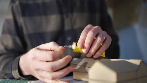 A man is cutting a piece of paper with a pair of scissors Video stock 302442633
