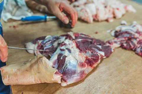 A man cutting pig meat on the table, butcher's work, processing pig meat Stock Photos