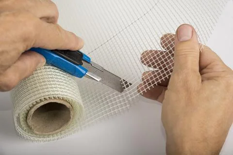 Man is cutting a plaster construction net Stock Photos