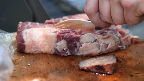 Man cutting raw beef fillet on steaks Stock Footage 116769282