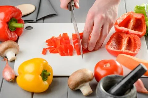 Man cutting a red pepper into a medium dice Stock Photos