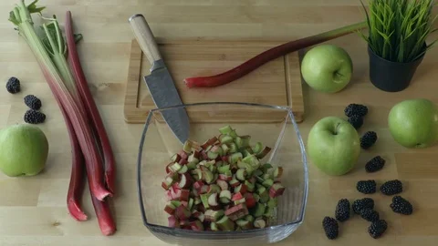 Man cutting rhubarb on the kitchen table view from above. Stock Footage 75623136