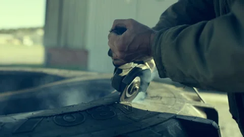 Man cutting a rubber tire with a device Stock Footage 279007795