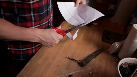 Man cutting a shape out of piece of paper Stock Footage 99908644