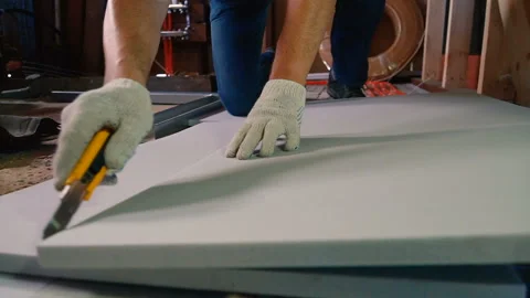 A man is cutting a sheet of insulation with a knife Stock Footage 111672832