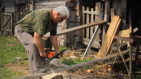 A man is cutting some wood using a chainsaw Video stock 64652345