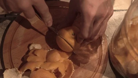 Man cutting a tangerine in his kitchen close-up 4k. Stock Footage 85774760