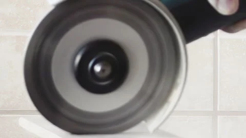 A man cutting the tile with an electric angle grinder, close up.Renovation of Video stock 253679549