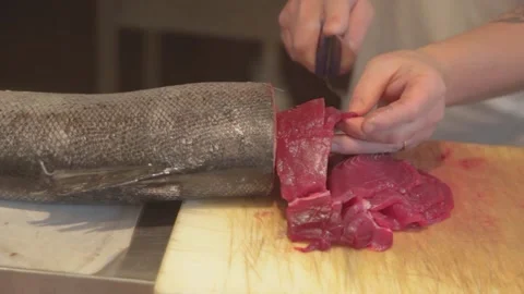 Man cutting tuna fillet. Cut into pieces of tuna fillet on a wooden board Stock Footage 166318108