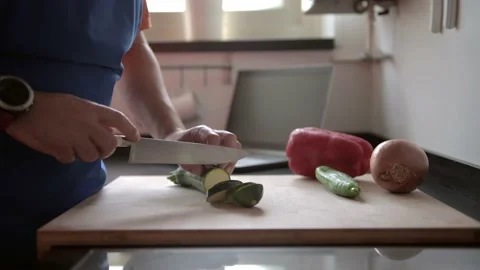 Man cutting vegetables in the kitchen at home Stock-Footage 136410428
