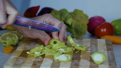 Man is cutting vegetables in the kitchen, slicing green bell pepper Stock Footage 98201369