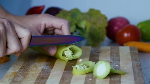 Man is cutting vegetables in the kitchen, slicing green bell pepper Stock Footage 98201517