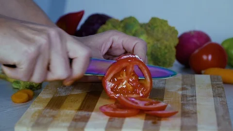 Man is cutting vegetables in the kitchen, slicing tomato closeup footage Stock Footage 98201585