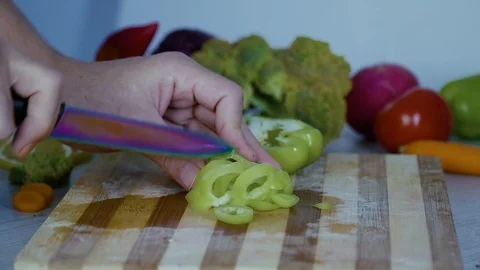 Man is cutting vegetables in the kitchen, slicing green bell pepper Stock Footage 98201640