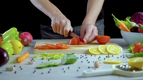 Man is cutting vegetables in the kitchen, slicing tomato Stock Footage 98201739