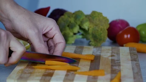 Man is cutting vegetables in the kitchen, slicing carrot, closeup view Stock Footage 98201876