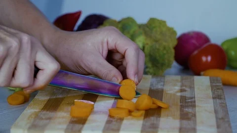 Man is cutting vegetables in the kitchen, slicing carrot Видео 98201948