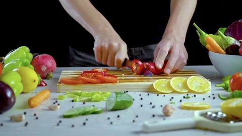 Man is cutting vegetables in the kitchen, slicing red bell pepper Stock Footage 98202006