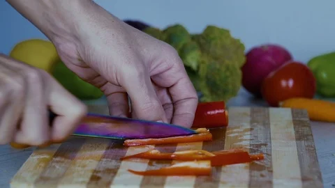 Man is cutting vegetables in the kitchen, slicing red bell pepper, close up view Stock Footage 98202071