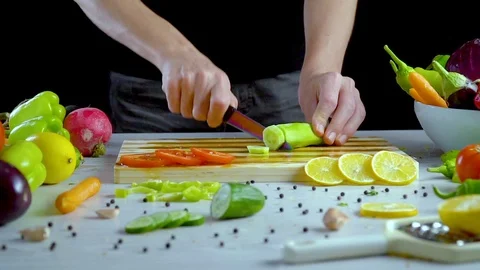 Man is cutting vegetables in the kitchen, slicing cucumber Video stock 98202625