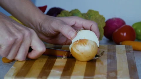 Man is cutting vegetables in the kitchen, slicing onion Stock Footage 98202678