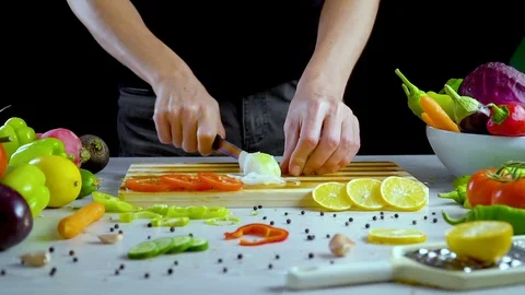 Man is cutting vegetables in the kitchen, slicing onion Stock Footage 98202691