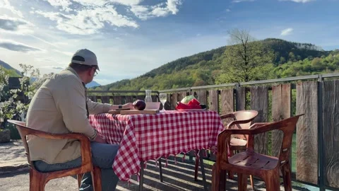 Man Cutting Vegetables on Outdoor Table in Scenic Countryside Stock Footage 333523380