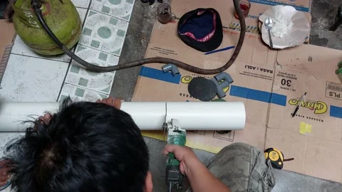 A man is cutting a water pipe with a machine Stock Footage 233645087