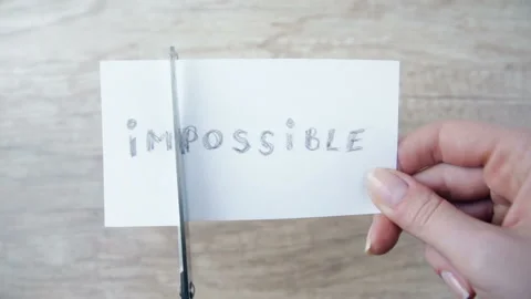 Man cutting word IMPOSSIBLE to read POSSIBLE. Concept of think positive Stock Footage 122056163