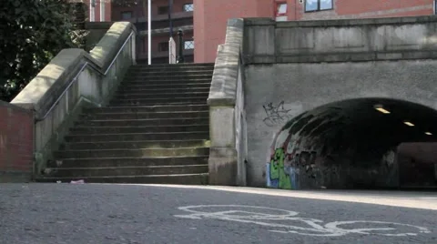 Man cycles under bridge, on cycle path by canal, Reading, Berkshire Stock Footage 5296816