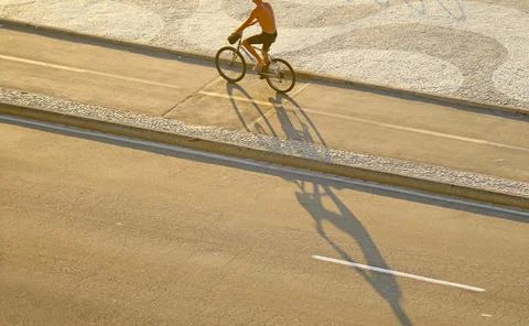 Man cycling along the wave pattern sidewalk, Copacabana beach, Brazil Stock Photos