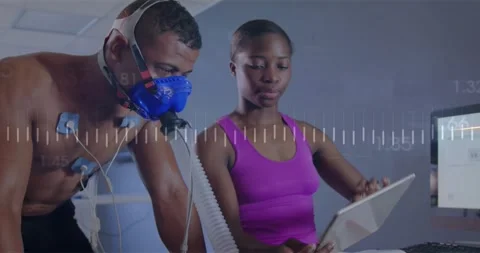 Man cycling, breathing into mask, causing graphs, tech scrolling tablet showing Stock Footage 330546572