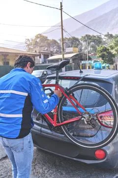 Man cyclist guard loading his bicycle on a rack of his crossover car, safety  Stock Photos