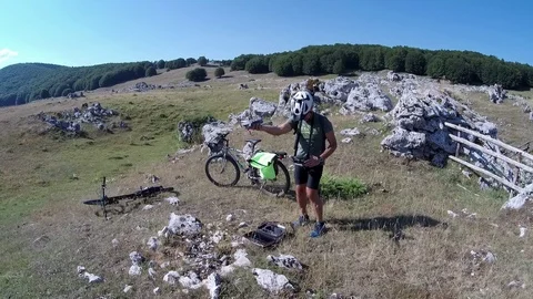  A man Cyclist on a mountain path does a drone take-off from the hand Stock Footage 113284751