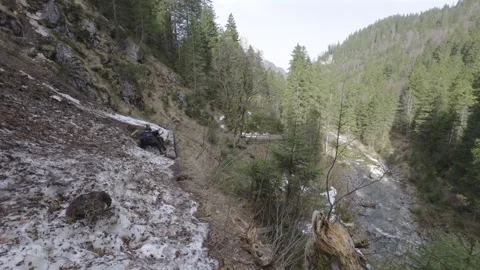 Man cyclist pulls bicycle through avalanche in mountains. Bicyclist is trapped Stock Footage 285054178