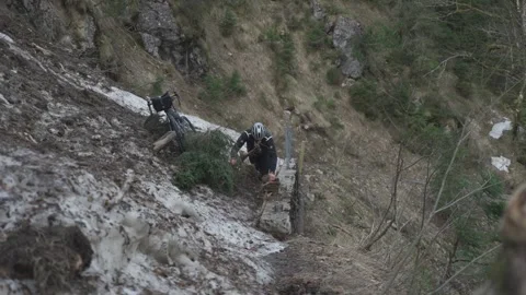 Man cyclist pulls bicycle through avalanche in mountains. Bicyclist is trapped Stock Footage 285054192