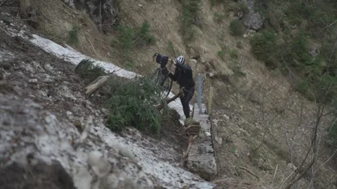 Man cyclist pulls bicycle through avalanche in mountains. Bicyclist is trapped Stock Footage 316636966