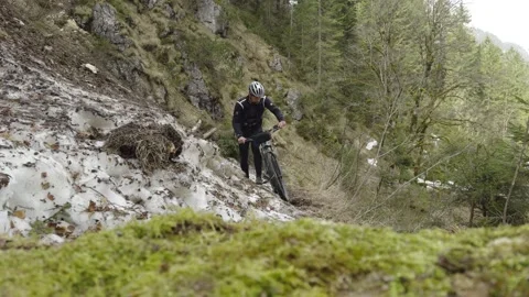 Man cyclist pulls bicycle through avalanche in mountains. Bicyclist is trapped Video stock 316638078