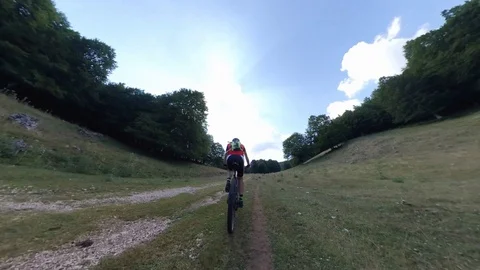A man cyclist rides fast on a climb in the woods, vr360 effect Stock Footage 113055020