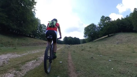 A man cyclist rides fast on a climb in the woods, vr360 effect Stock Footage 113055059