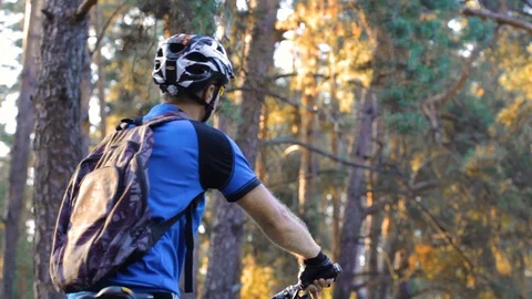 Man cyclist rides paths in the Pine Forest Stock Footage 129942830