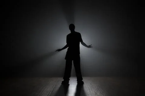 Man dancer posing in the dark and smoke Stock Photos