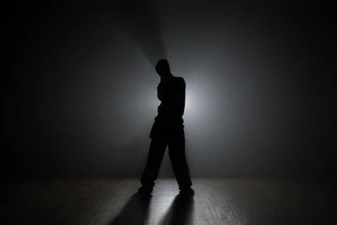 Man dancer posing in the dark and smoke Stock Photos