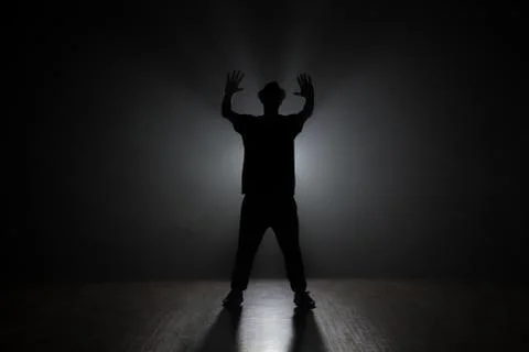 Man dancer posing in the dark and smoke Stock Photos
