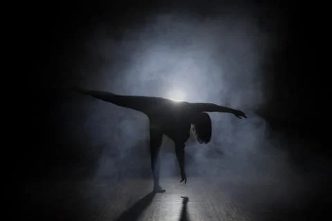 Man dancer posing in the dark and smoke Stock Photos