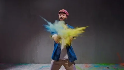 Man dancer showing break-dancing moves against colourful powder explosion. Stock Footage 119652493
