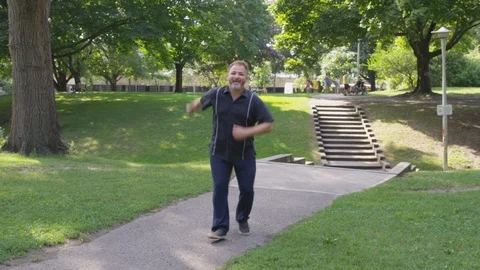 A man dances about at the park outside - shot on RED Stock Footage 124718318
