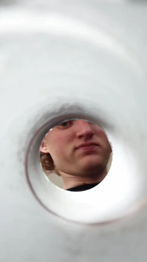 Man dances and looks through pipe Stock Footage 337160448
