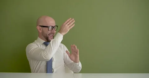 A man dances excitedly at the work table Stock Footage 267087882
